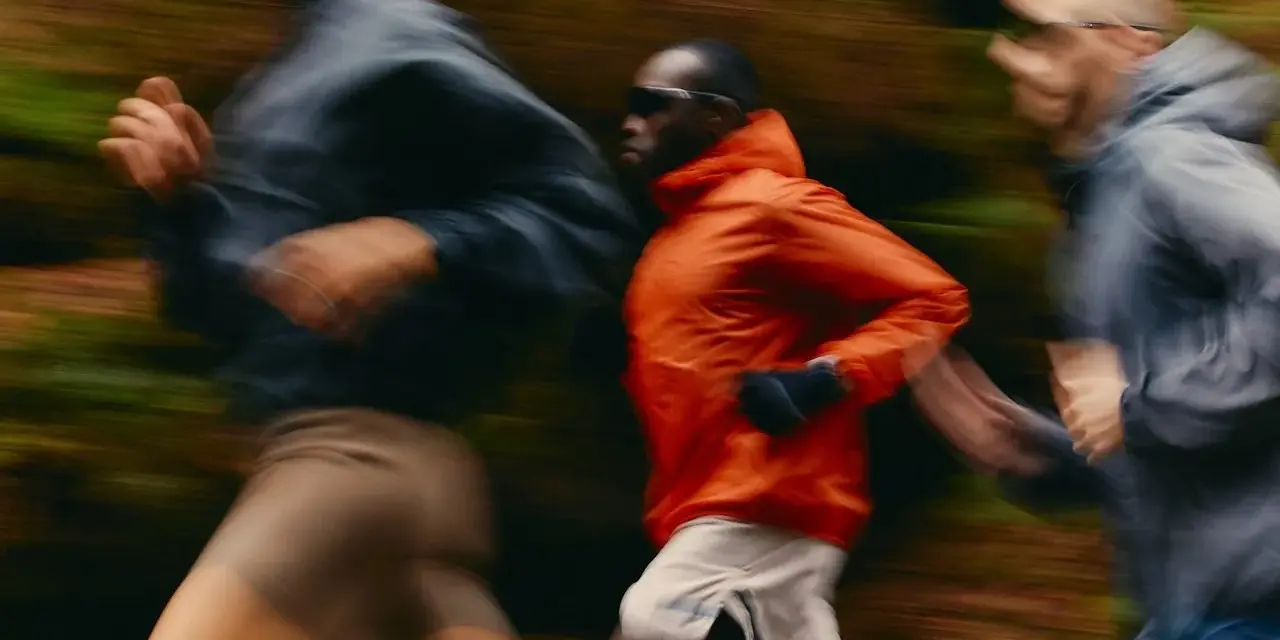 Trois coureurs en mouvement dans un décor forestier, suivant un programme reprise course à pied.