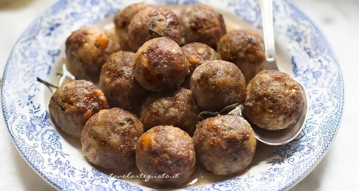 Polpette dorate e succulente in friggitrice ad aria, servite su un piatto con decori blu.