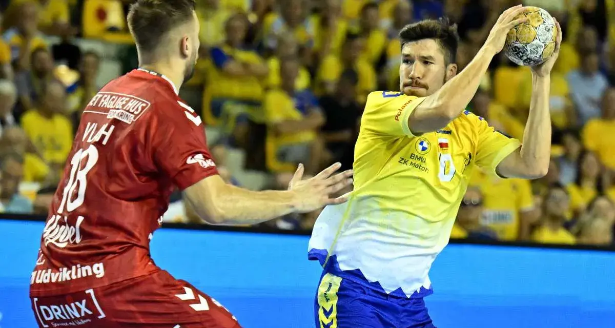 Piłkarz Aalborg Handball w żółtej koszulce rzuca piłkę, obok zawodnik w czerwonej.
