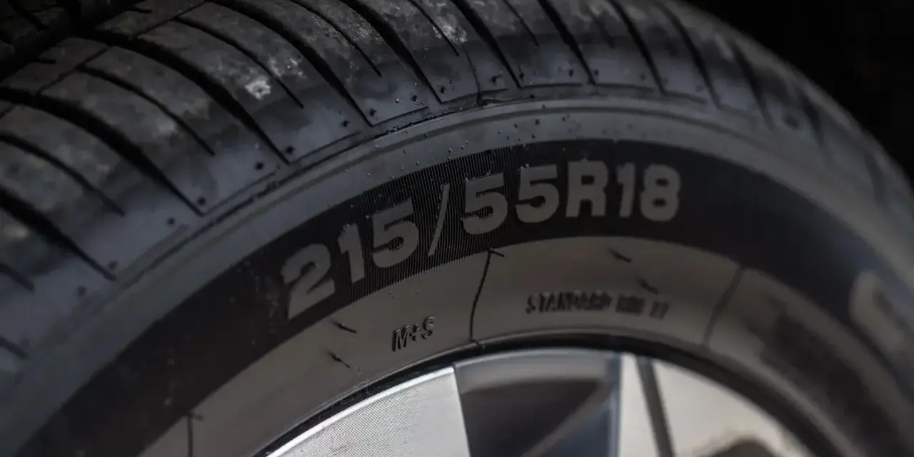 Zbliżenie na oponę z oznaczeniem 215/55R18. Widoczne oznaczenie M+S potwierdza, że jest to oznaczenie opon wielosezonowych, gotowych na każdą pogodę.
