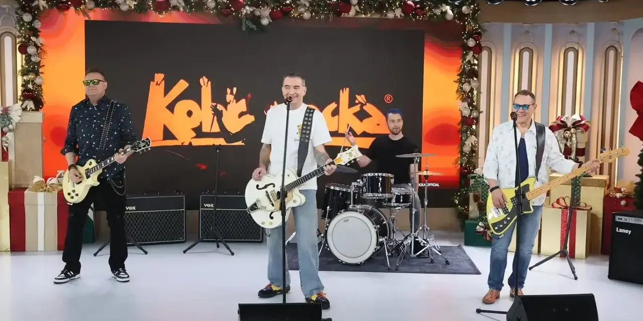 Zespół Kobranocka gra na scenie, w tle logo zespołu. Muzycy prezentują swoje utwory w świątecznej scenerii.