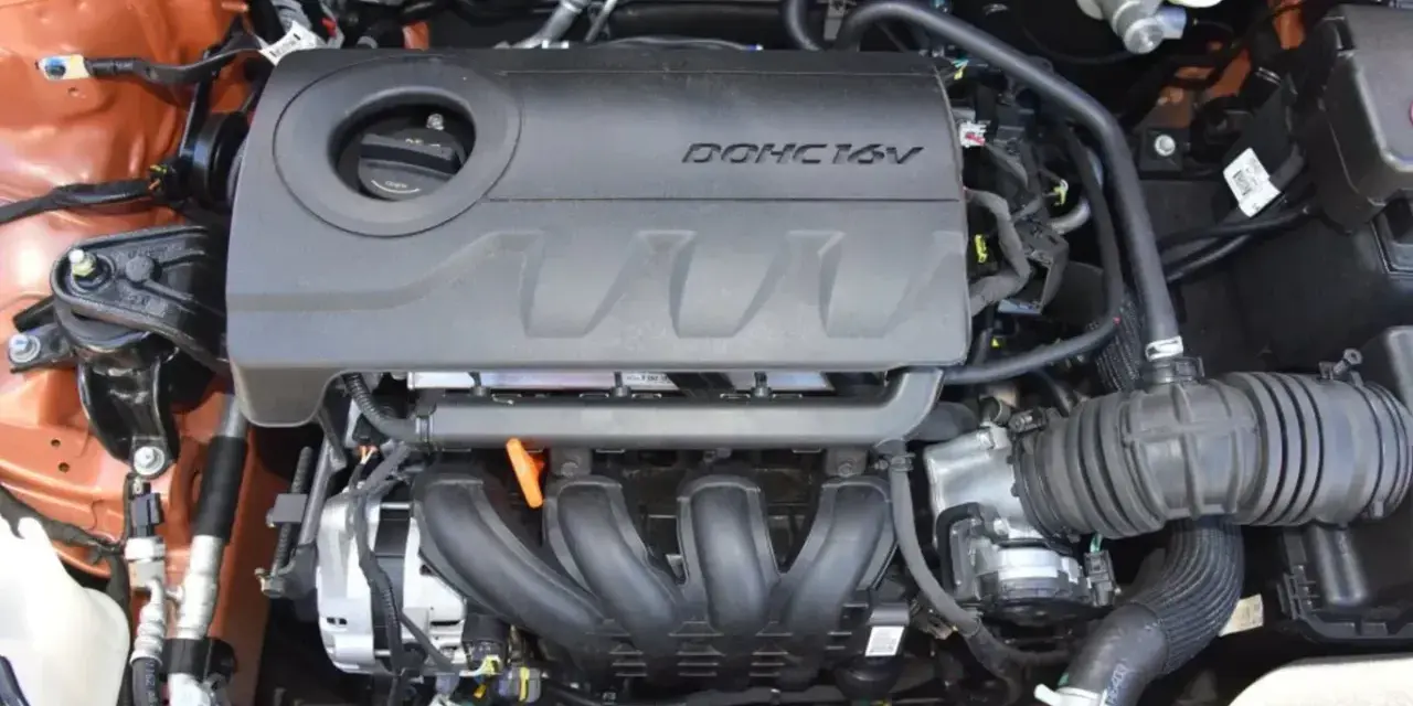 Silnik MPI DOHC 16V, widok z góry. Widać kolektor dolotowy, osłonę silnika i elementy układu dolotowego.