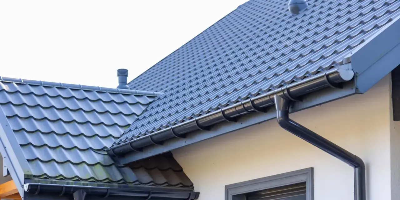 Szary dach z dachówki ceramicznej, idealny do obliczenia dachówka ceramiczna cena za m2. System rynnowy odprowadza wodę.