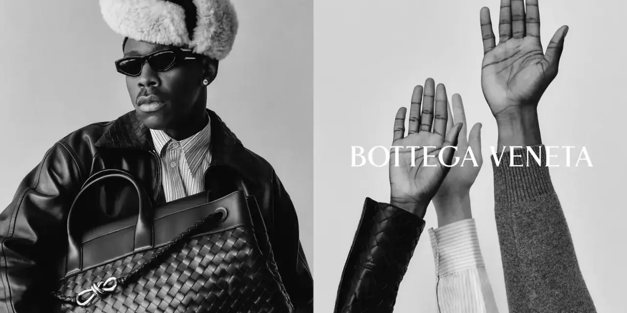 Uomo con cappello di pelliccia e borsa Bottega Veneta, mani alzate. Un omaggio alla storia del brand.