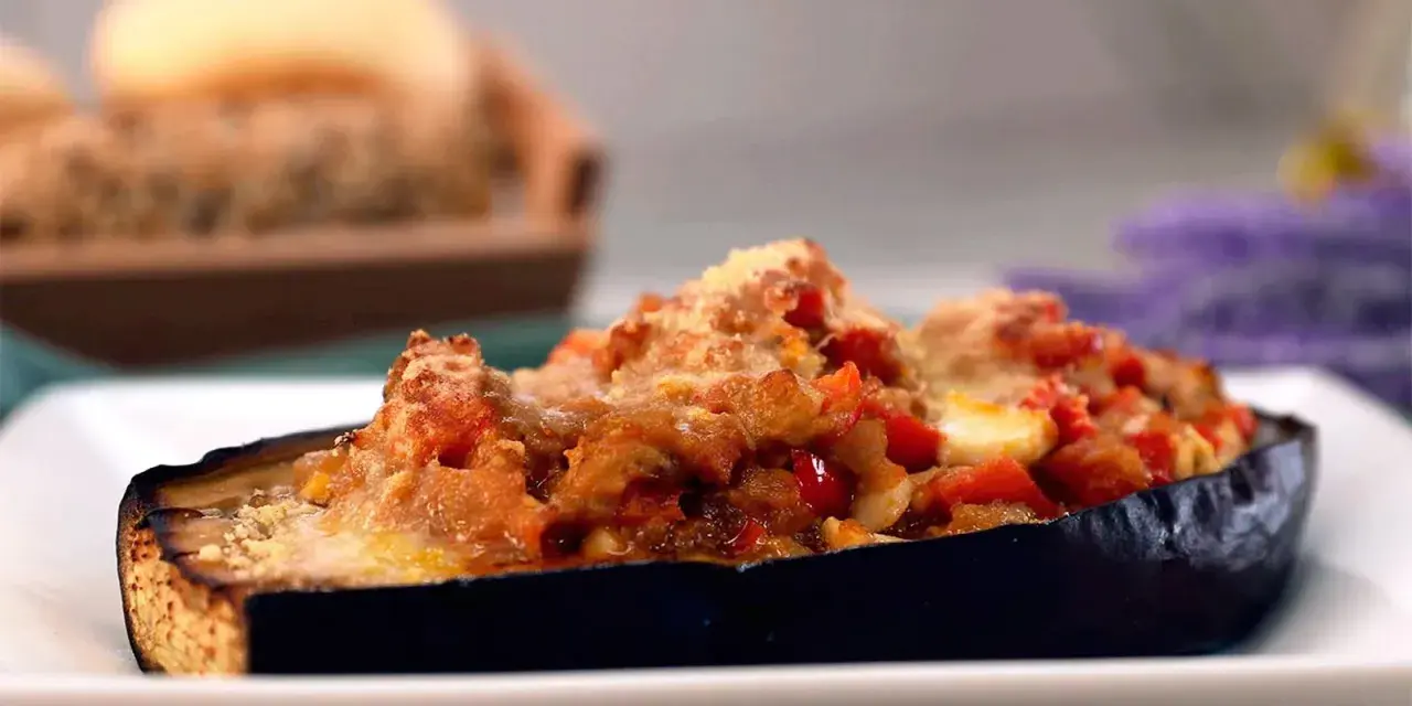 Berenjenas rellenas de atún, gratinadas con queso y trocitos de tomate. Un plato delicioso y fácil de preparar.