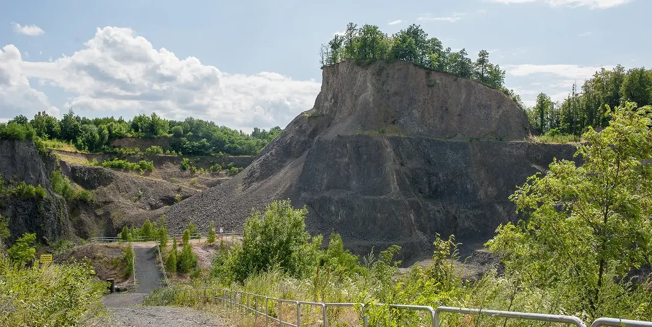 Kamieniołom przypomina wilczą górę, z której wyrasta bujna zieleń. Ścieżka prowadzi w głąb skalistego krajobrazu.
