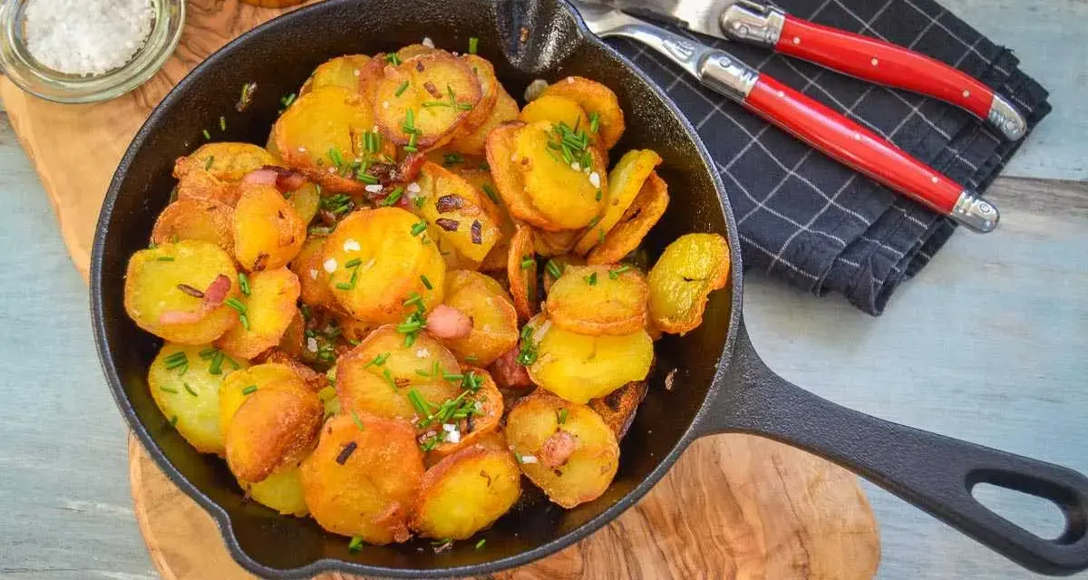 Goldbraune Bratkartoffeln mit Speck und Schnittlauch in der Pfanne. Perfekt als Beilage, denn dazu passt fast alles!