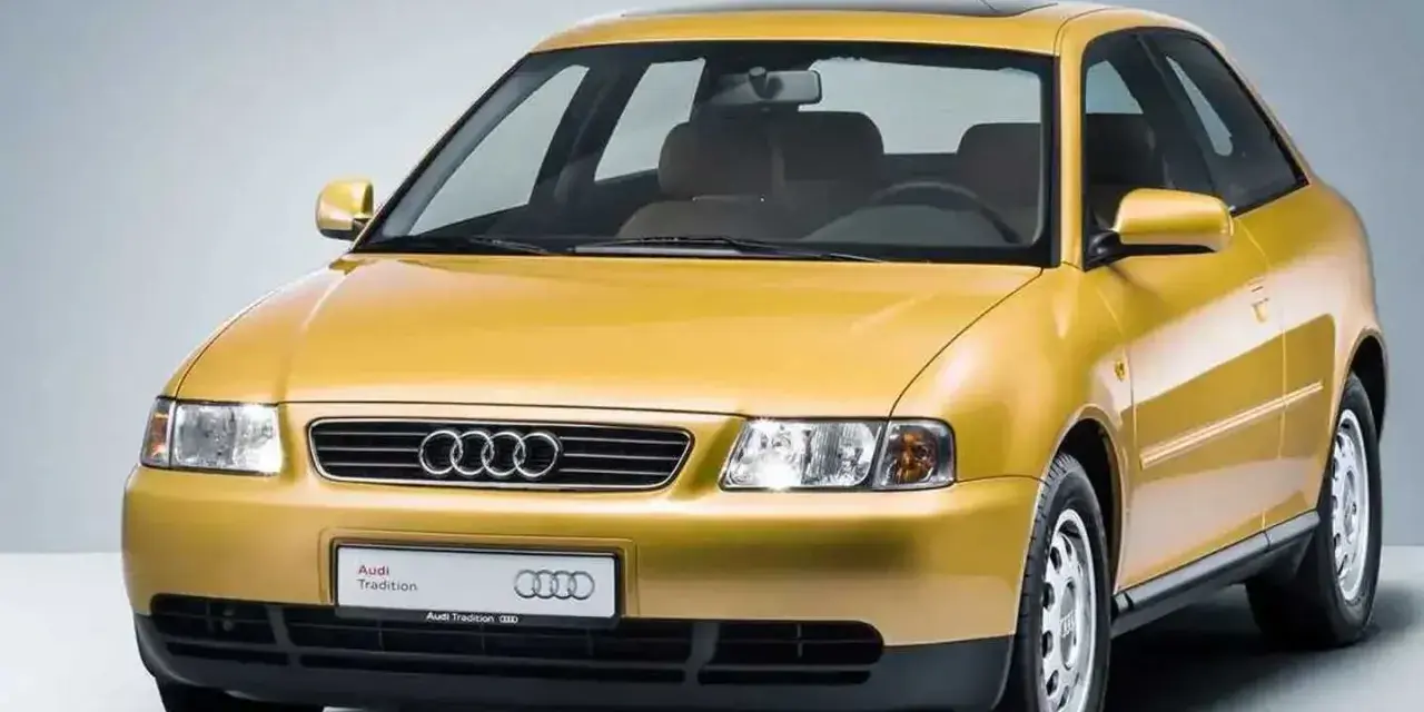 Gelber Audi A3 Baujahr 2000, dreitürig, mit Schiebedach und dem Schriftzug "Audi Tradition".