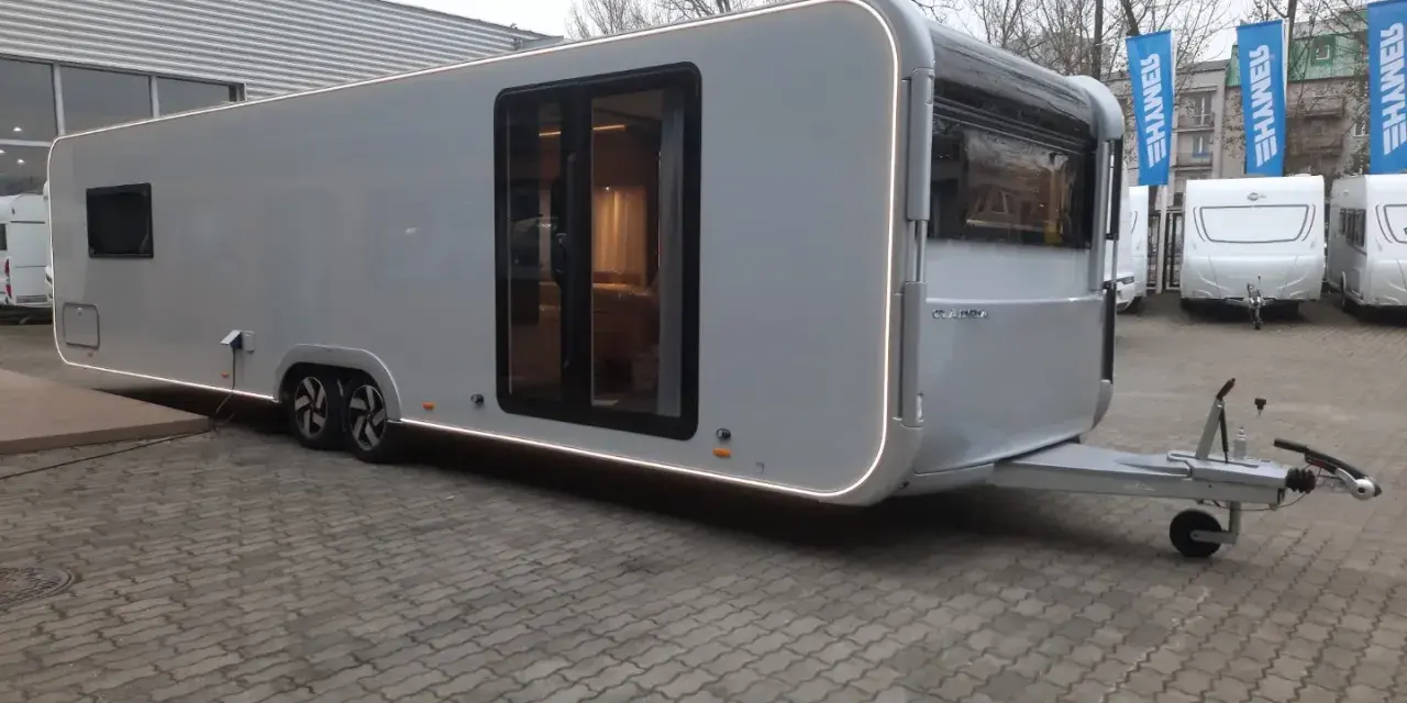 Nowy Adria Astella 904 HP, luksusowy caravan z panoramicznymi oknami i nowoczesnym designem, gotowy na podróże.