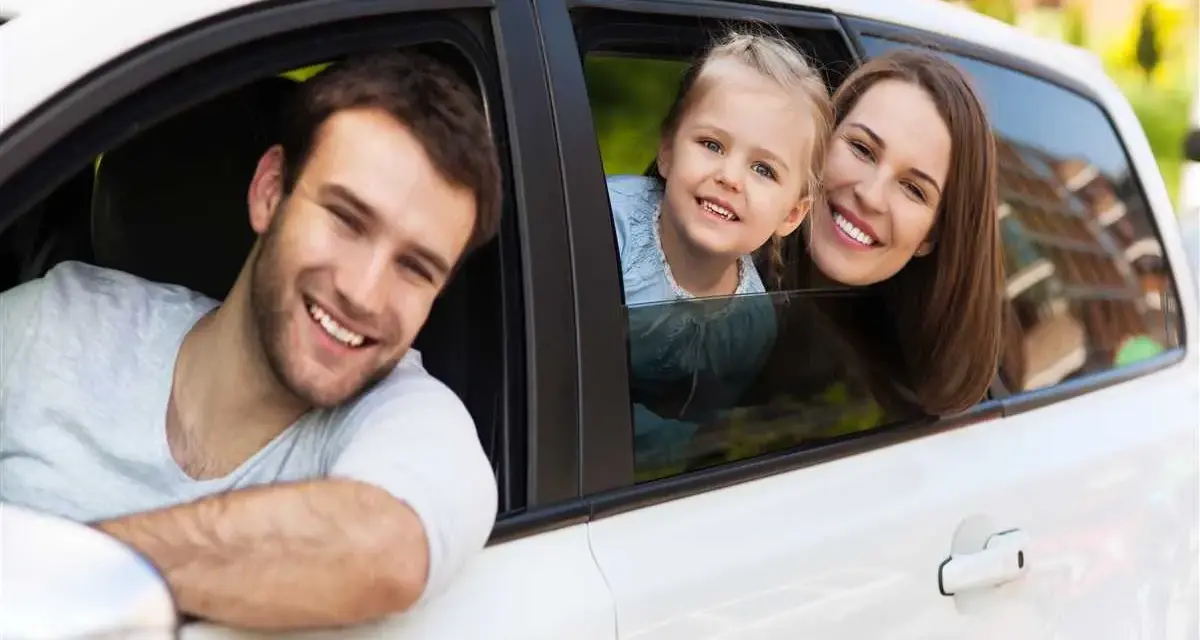 Famiglia felice in auto, un nuovo inizio dopo il passaggio di proprietà auto tra familiari.