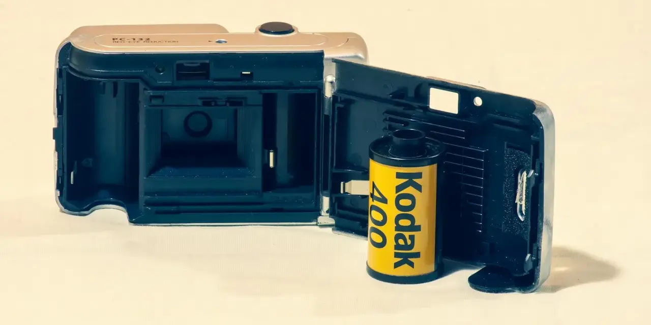 Otwarta klapka aparatu z włożonym rolką filmu Kodak 400. Klasyczny film analogowy gotowy do uchwycenia wspomnień.