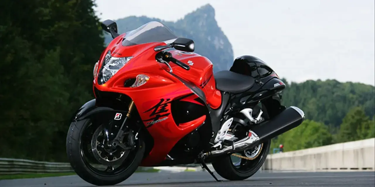 Czerwony motocykl Suzuki Hayabusa na drodze, z widokiem na góry. Poznaj jego suzuki hayabusa dane techniczne.