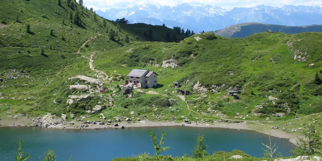Sentiero per il lago di Erdemolo, con rifugio e montagne sullo sfondo.