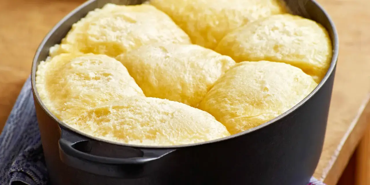 Frisch gebackene Dampfnudeln in einem schwarzen Topf. Ein köstliches Dampfnudel Rezept, das du unbedingt ausprobieren musst!