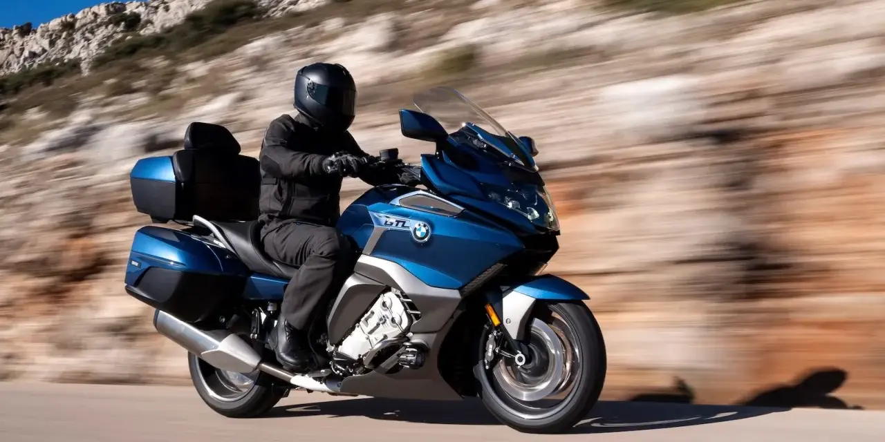 Motocyklista w kasku przemierza malowniczą trasę, odkrywając różne rodzaje turystyki.