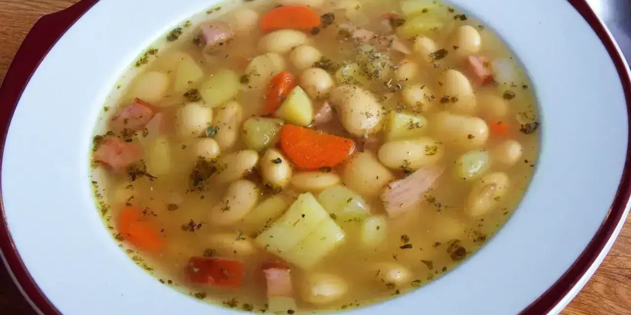 Aksamitna zupa fasolowa przepis babci, pełna białej fasoli, ziemniaków, marchewki i kawałków wędzonki. Aromatyczna i sycąca.