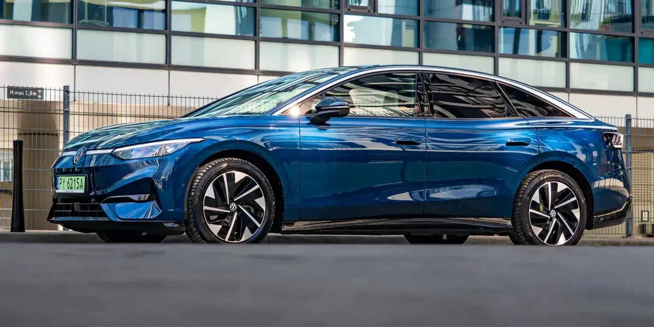 Niebieski Volkswagen ID.7 zaparkowany przed nowoczesnym budynkiem.