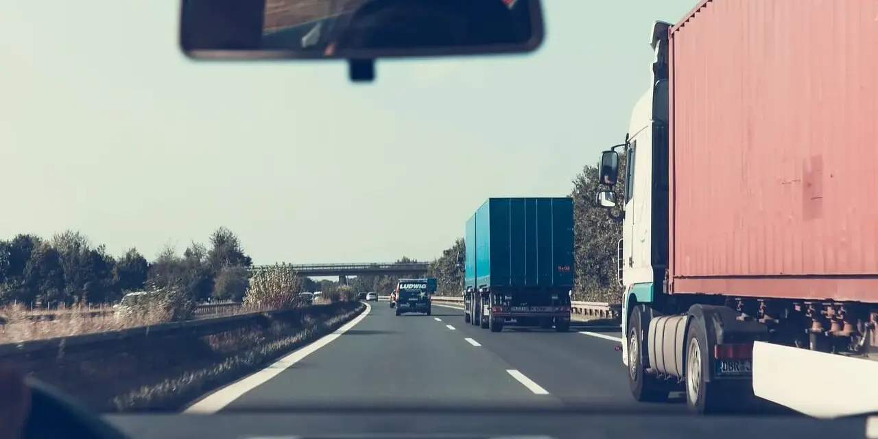 Jadąc autostradą, zastanawiam się, jakie kraje obejmuje zielona karta ubezpieczenia. W lusterku widzę inne ciężarówki.