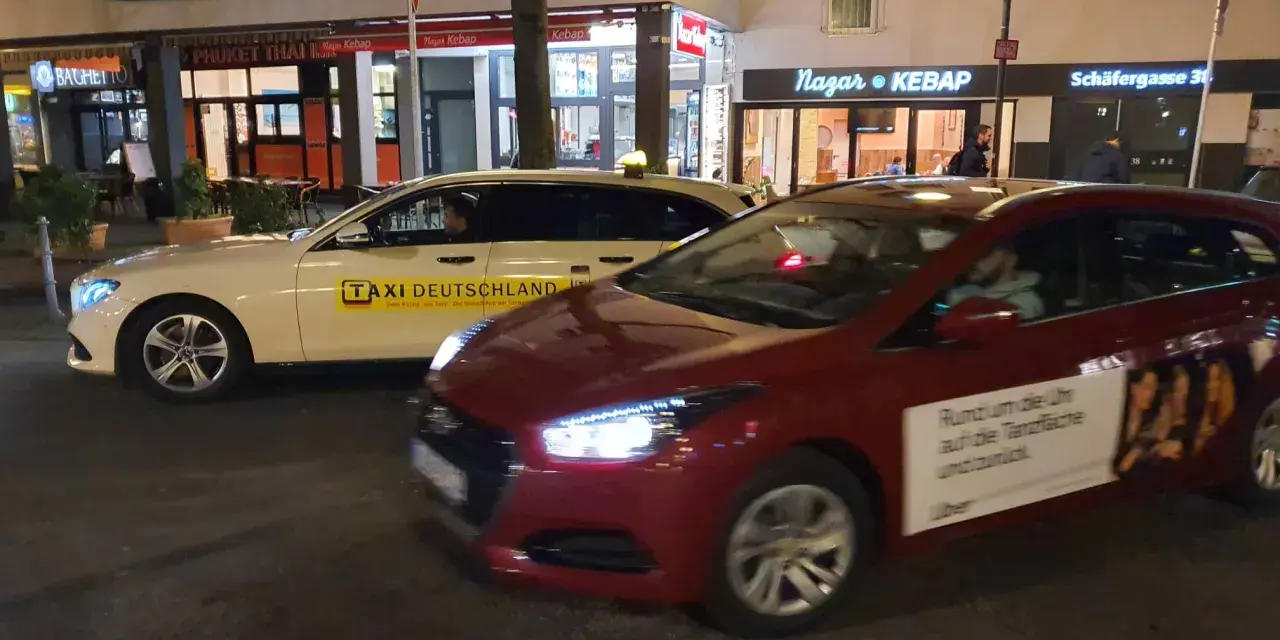 Ein weißes Taxi und ein rotes Auto mit Uber-Werbung stehen nebeneinander. Der Unterschied über Taxi ist die moderne Alternative.