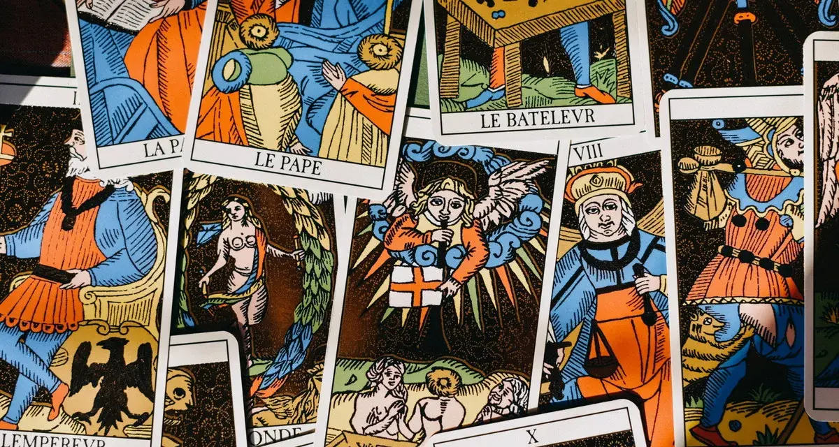Rozłożone karty tarota, w tym "Le Pape" i "Le Bateleur". Wśród nich widać postacie aniołów i ludzi, jakby kapłan tarot odsłaniał tajemnice przyszłości.