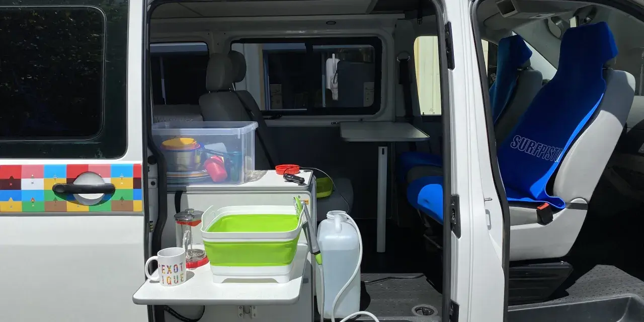 Aménagement intérieur d'un véhicule pour le transport de personnes moins de 9 places, avec coin cuisine et sièges.