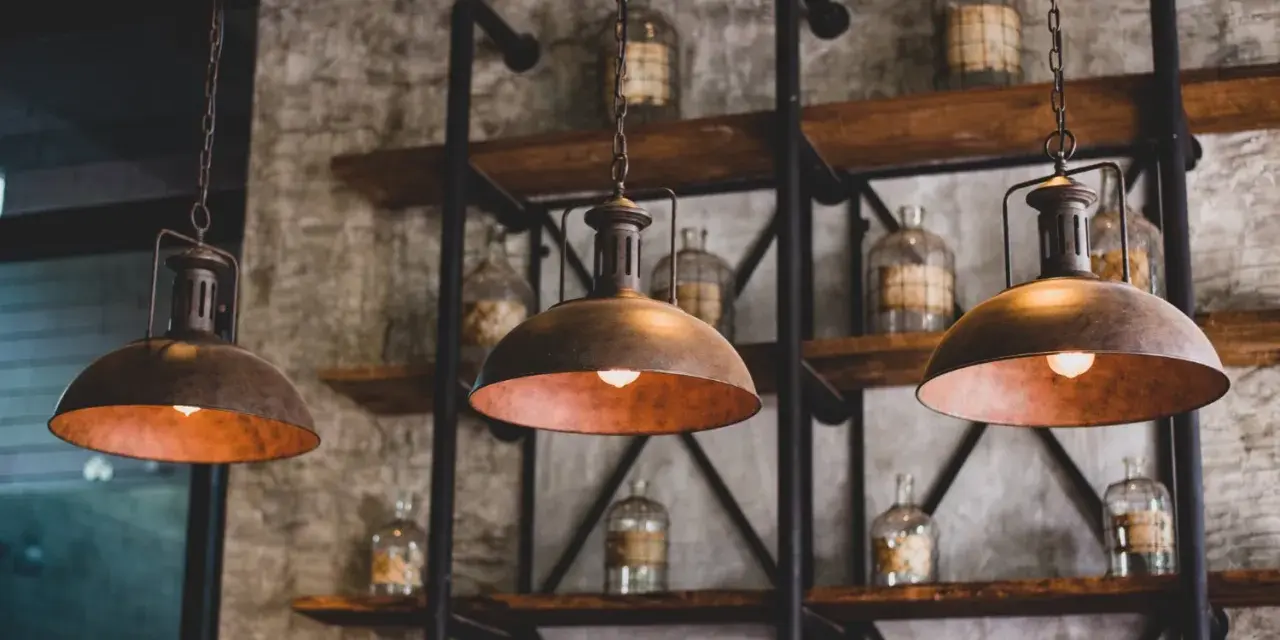Industrialne lampy wiszące nad półkami ze słoikami. Dowiedz się, jak wyczyścić abażur z lampy, by odzyskał dawny blask.