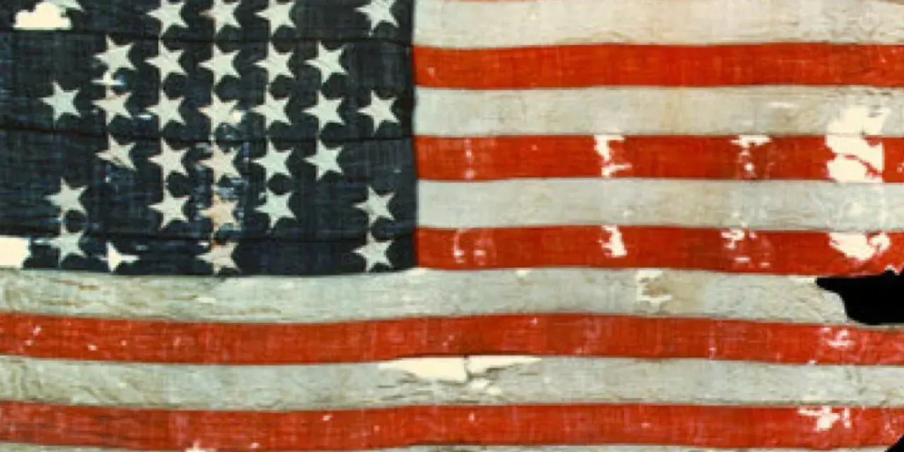 Pierwsza flaga USA, zniszczona i wyblakła, z 13 gwiazdami i pasami, świadectwo historii.