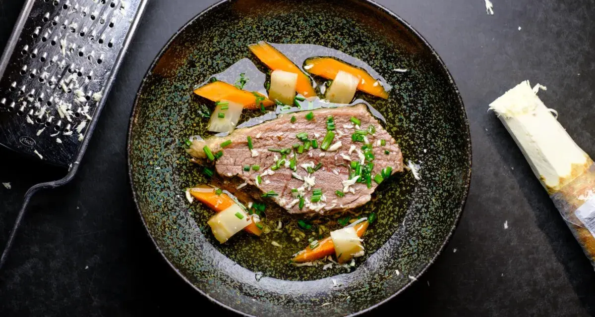 Zarter Tafelspitz braten im Topf, serviert mit Karotten und Lauch. Frisch geriebener Meerrettich daneben.