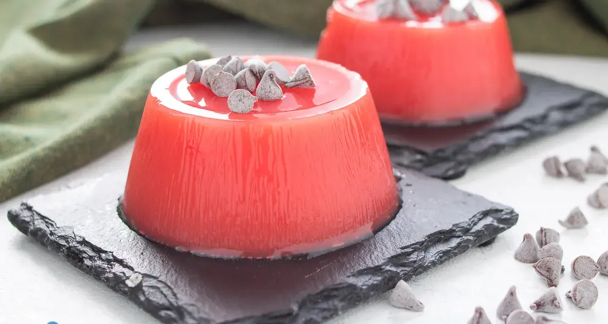 Delizioso gelo di melone, un dolce fresco e colorato, guarnito con gocce di cioccolato.