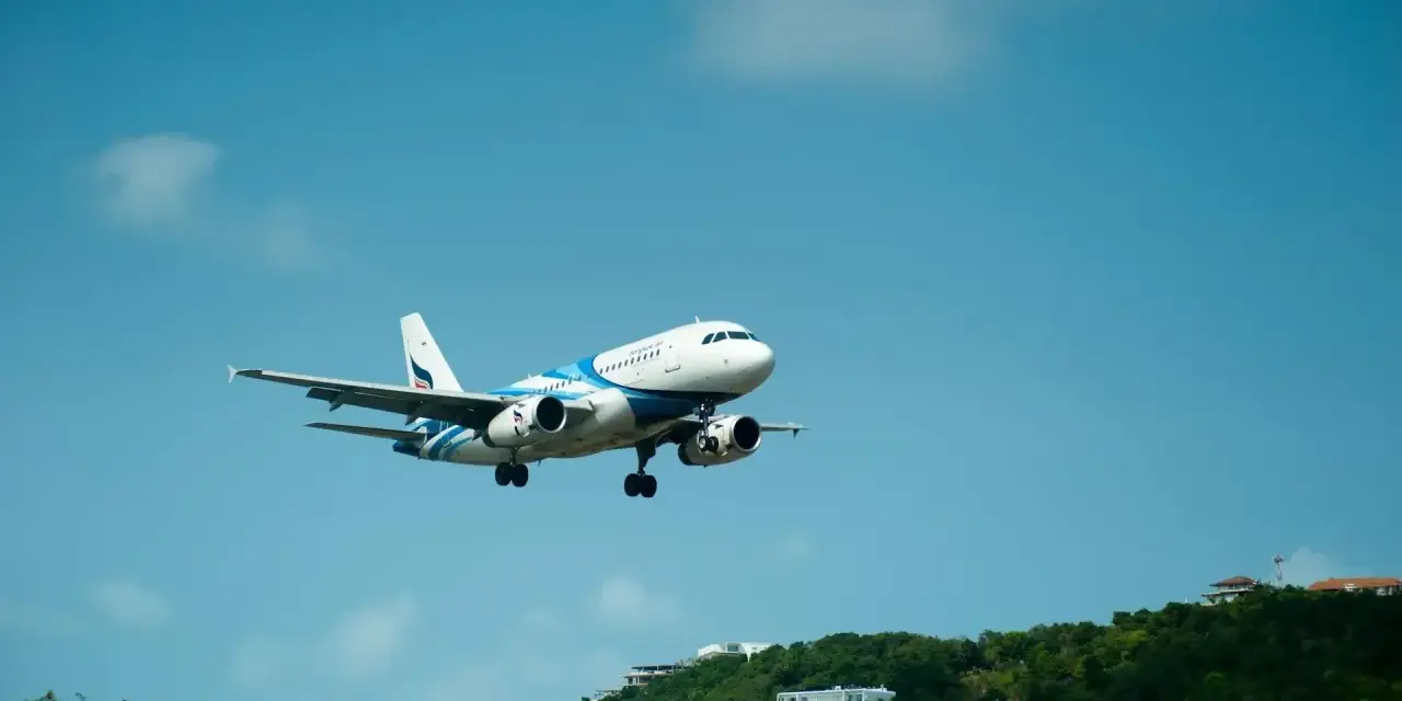 Samolot pasażerski z niebieskimi pasami na tle błękitnego nieba. Może to być przypomnienie o możliwości zwrotu biletu Ryanair zwrot biletu 24h.