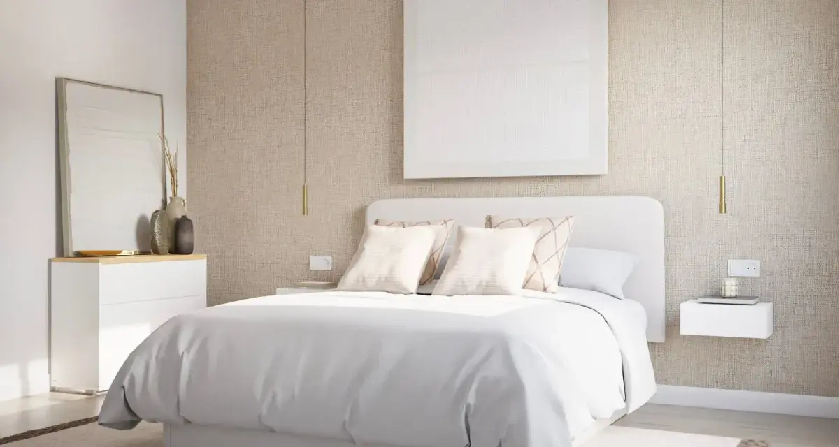 Una serena habitación blanca con cama vestida de blanco, mesitas de noche flotantes y un cuadro minimalista.