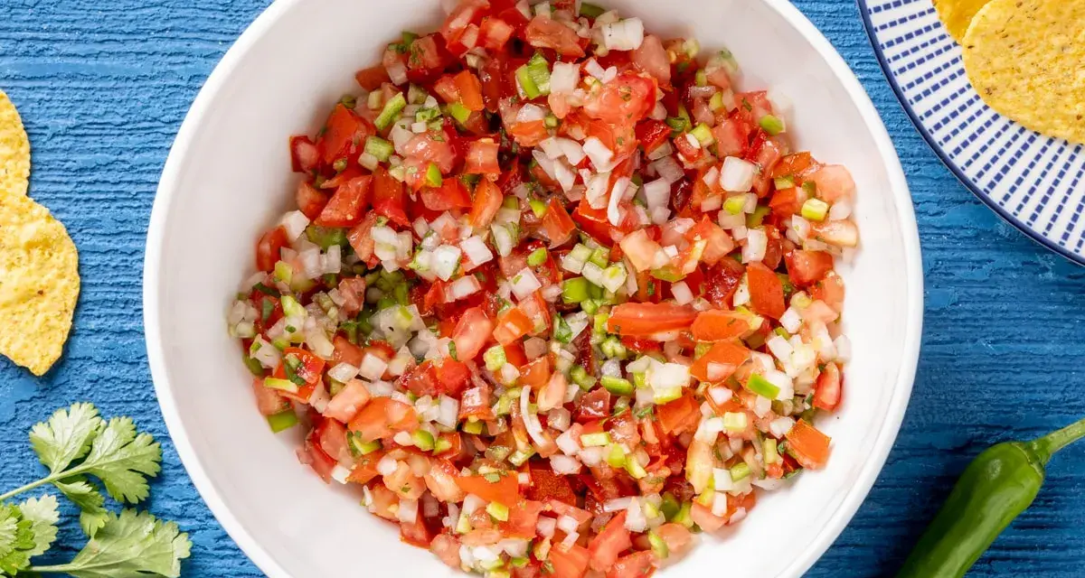 Pico de gallo ricetta: pomodori, cipolla, peperoncino e coriandolo freschi, pronti per essere gustati con nachos.
