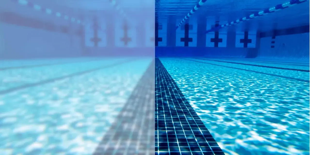 Underwater view of a swimming pool, half clear and half cloudy, with lane lines and lane markers.