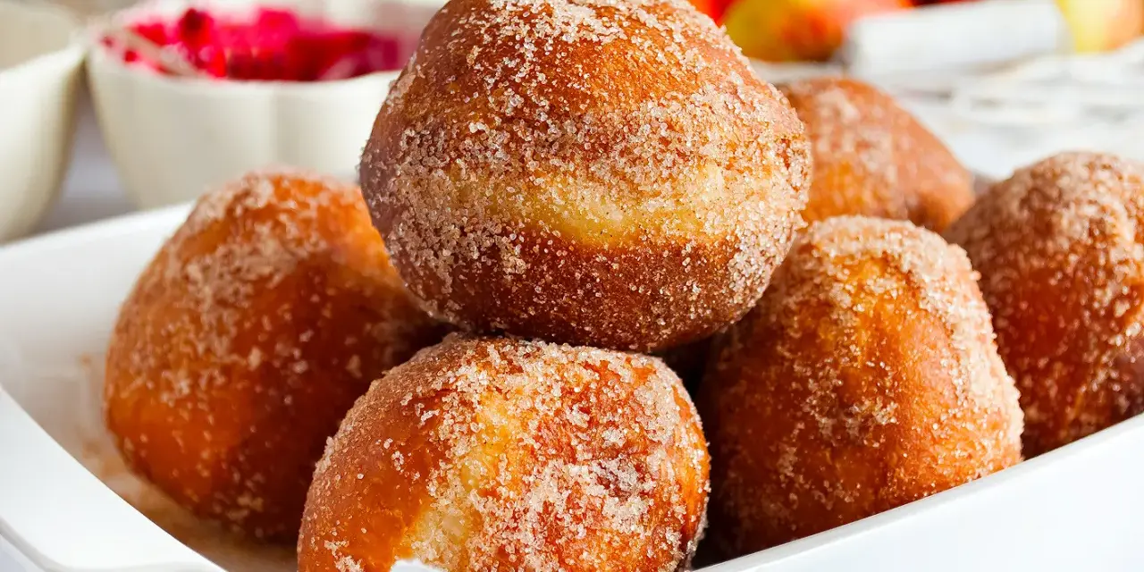 Puszyste pączki posypane cukrem z cynamonem, idealne na tłusty czwartek. Ten przepis na puszyste pączki to gwarancja sukcesu.