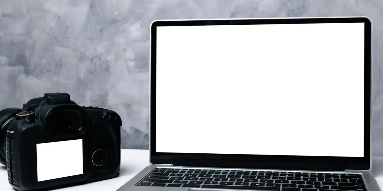 Aparat fotograficzny i laptop z pustym ekranem. Idealne do nauki, jak zgrać zdjęcia z aparatu na komputer.