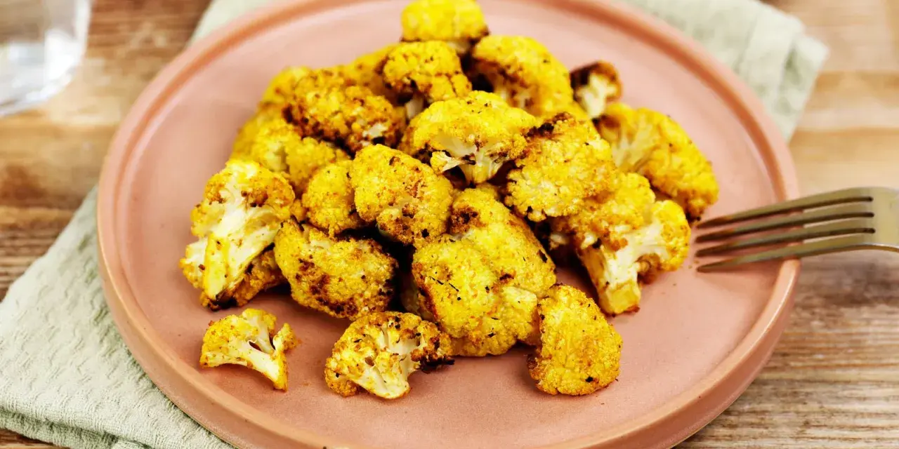 Goldbrauner Blumenkohl aus dem Airfryer, perfekt gewürzt und auf einem Teller angerichtet. Ein gesunder Genuss!