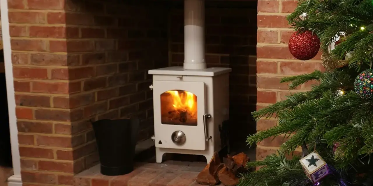 Installation d'un poêle à granulés avec conduit existant dans une cheminée en briques, décorée pour Noël.