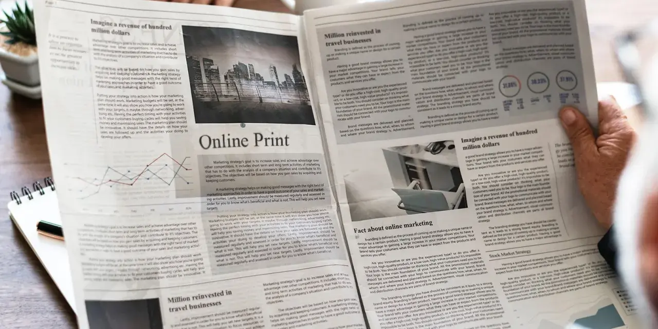 Manos sostienen un periódico con artículos sobre marketing y finanzas, impreso en gramaje papel normal.