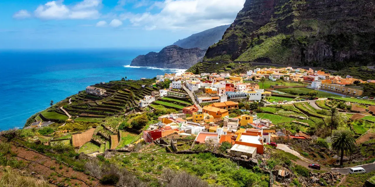 Kolorowa wioska na zboczu góry, tarasowe pola i ocean. To jedne z wielu **la gomera atrakcje**, które zachwycają.
