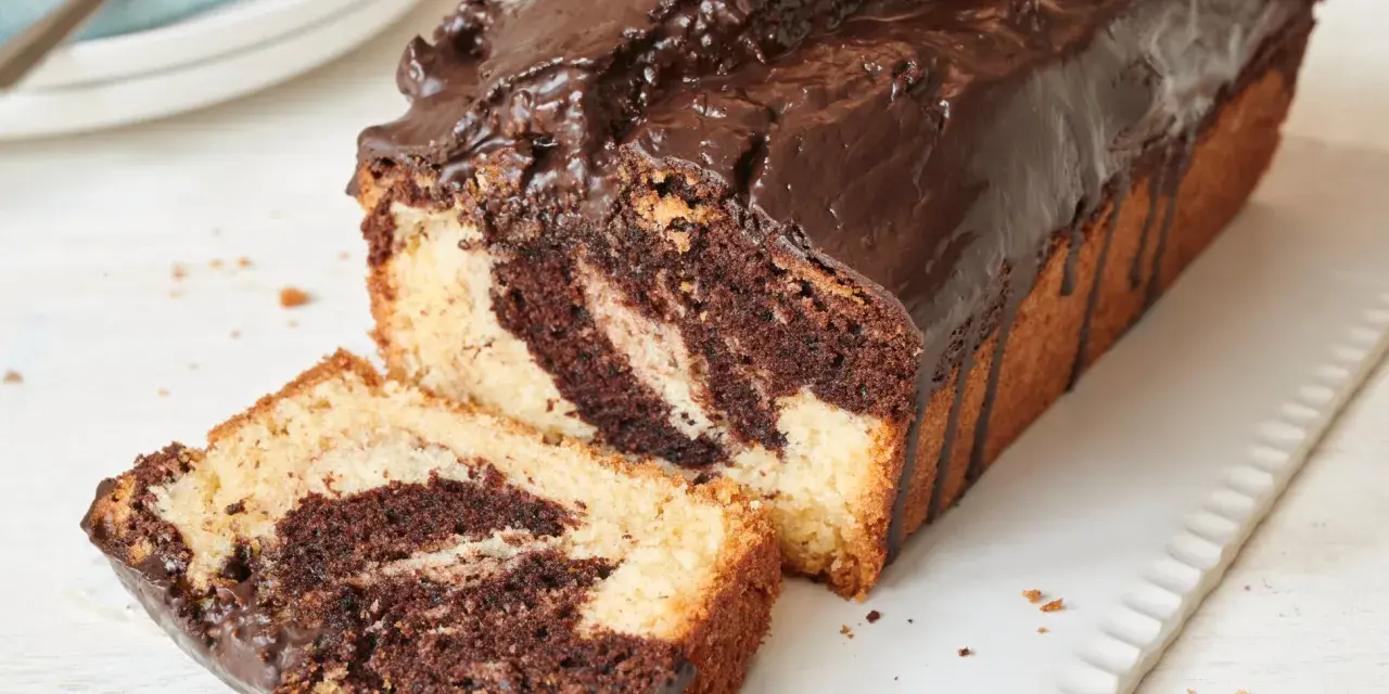 Saftiger Marmorkuchen, frisch aus dem Airfryer, mit Schokoladenglasur und einer angeschnittenen Scheibe.