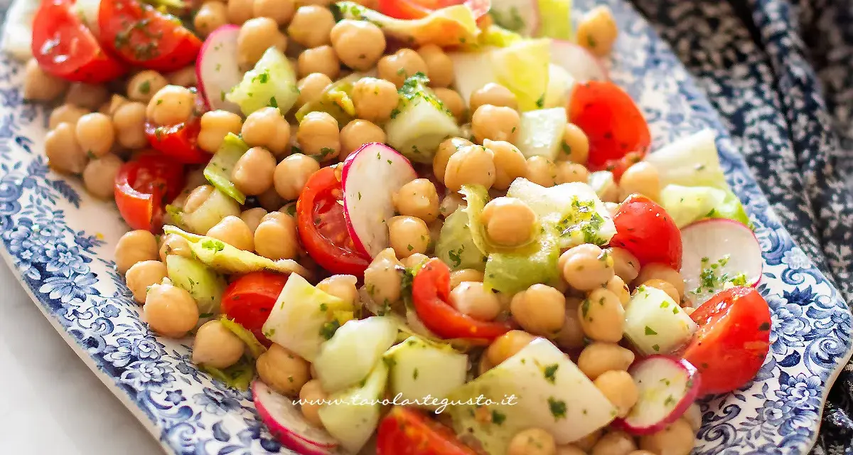 Un'insalata di legumi colorata e fresca con ceci, pomodorini, cetrioli e ravanelli, condita con erbe aromatiche.