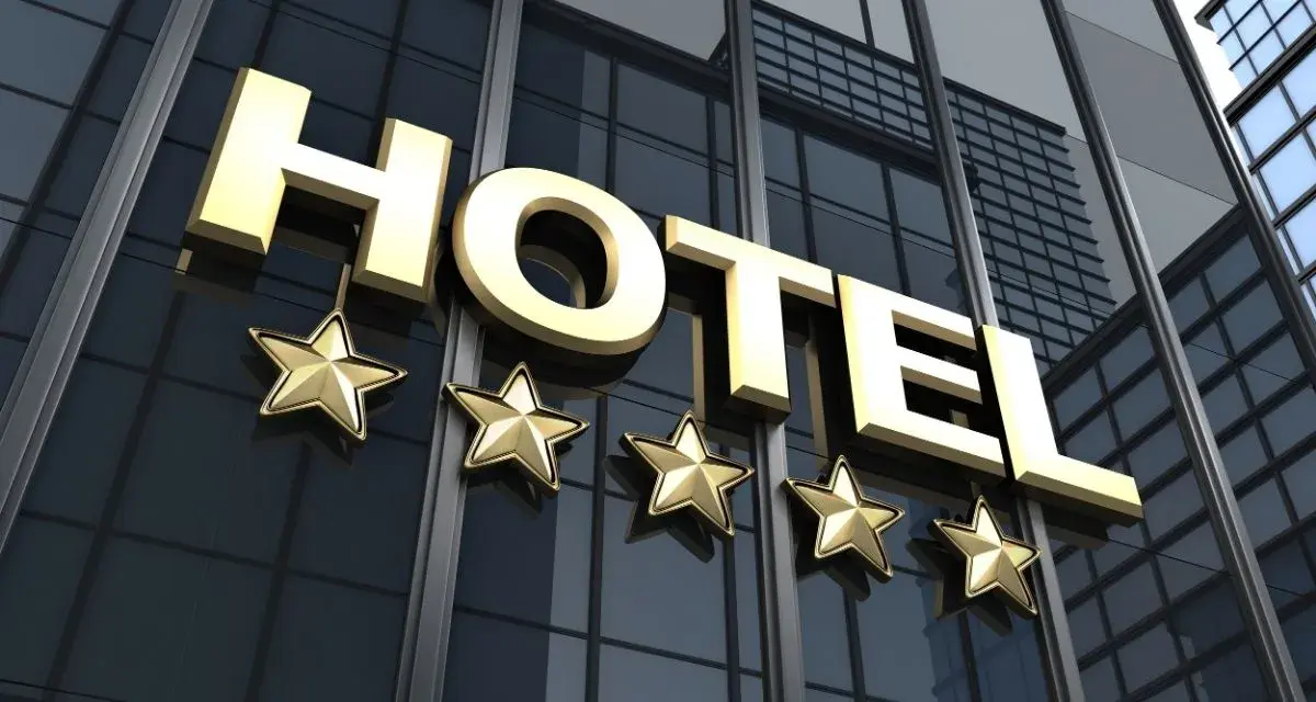 Złoty napis HOTEL i pięć gwiazdek na nowoczesnym budynku. Marzysz, jak zostać testerem hoteli w Polsce?