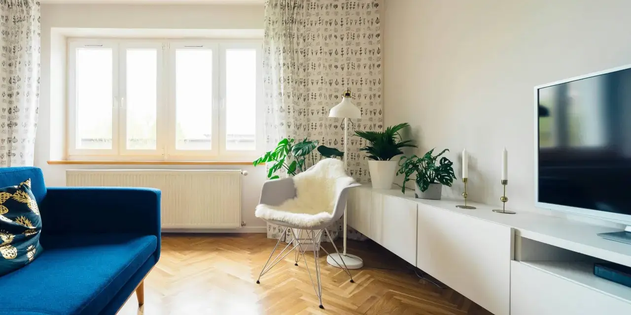 Jasna podłoga w jodełkę świetnie komponuje się z niebieską kanapą i białymi meblami. To inspiracja, jak dobrać kolor podłogi do mebli, tworząc harmonijną przestrzeń.