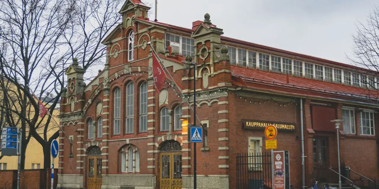 Targowisko Kauppahalli w Turku, najstarszym mieście w Finlandii, z charakterystyczną ceglaną fasadą i czerwonym dachem.