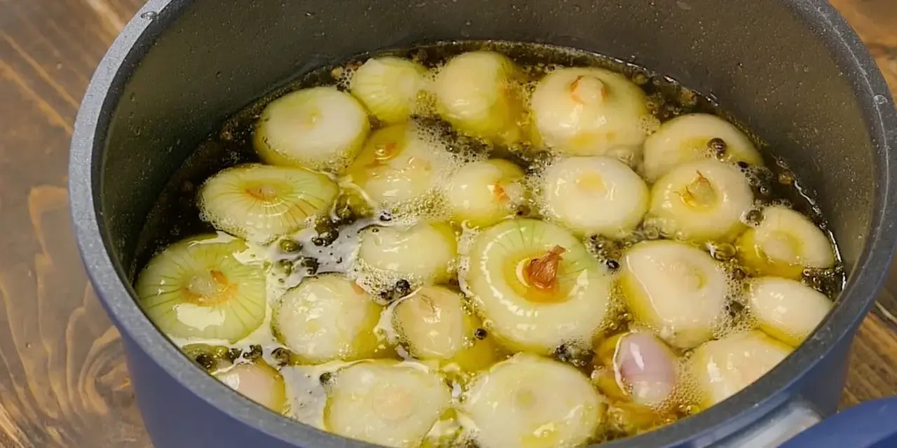 Cipolline in agrodolce in cottura, pronte per essere conservate in barattolo.