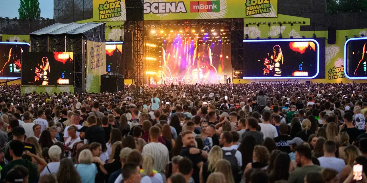 Tłum ludzi na koncercie podczas Łódź Summer Festival. Na scenie artystka, a nad nią wielkie ekrany z jej wizerunkiem.
