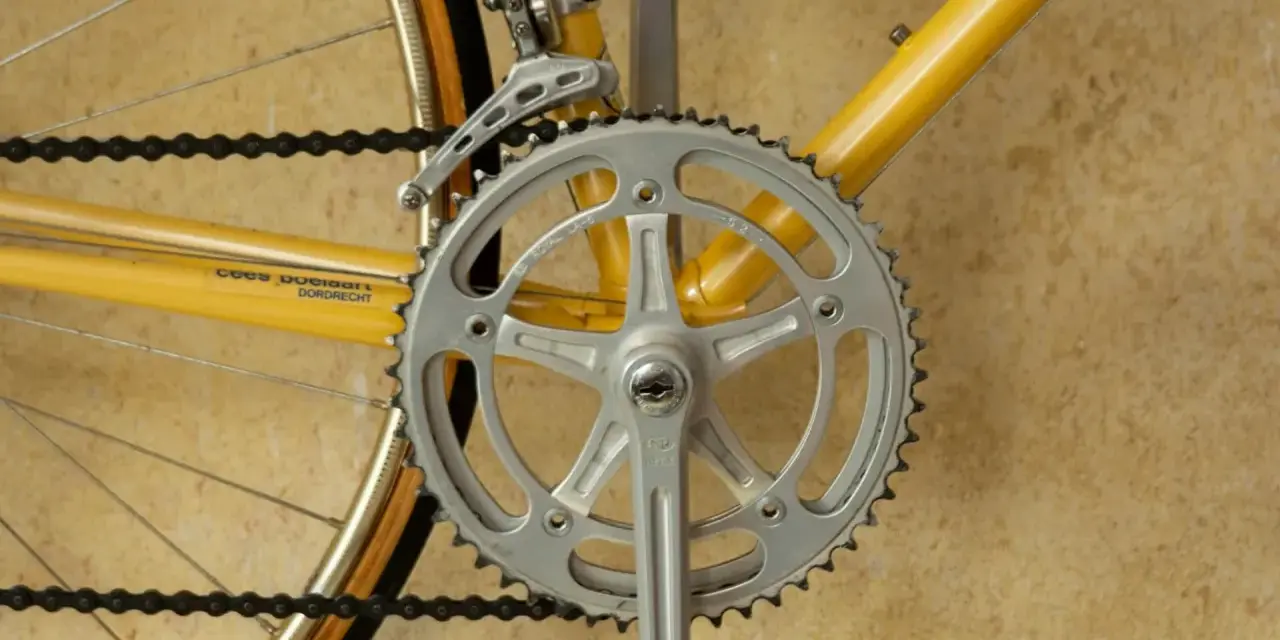 Detaljerad bild av en cykels vevparti och framdrev, perfekt för att visa hur man kan byta framdrev cykel för bättre prestanda.