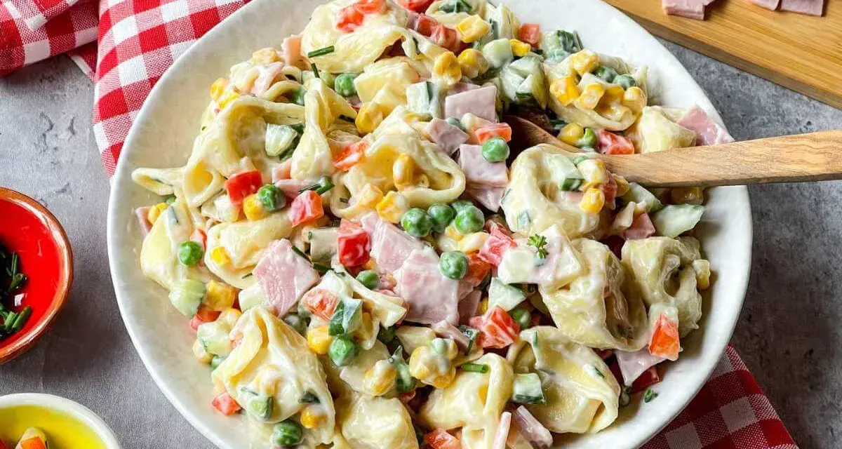 Cremiger Tortellini Salat mit Erbsen, Mais, Paprika und Schinken. Ein perfekter Sommergenuss!