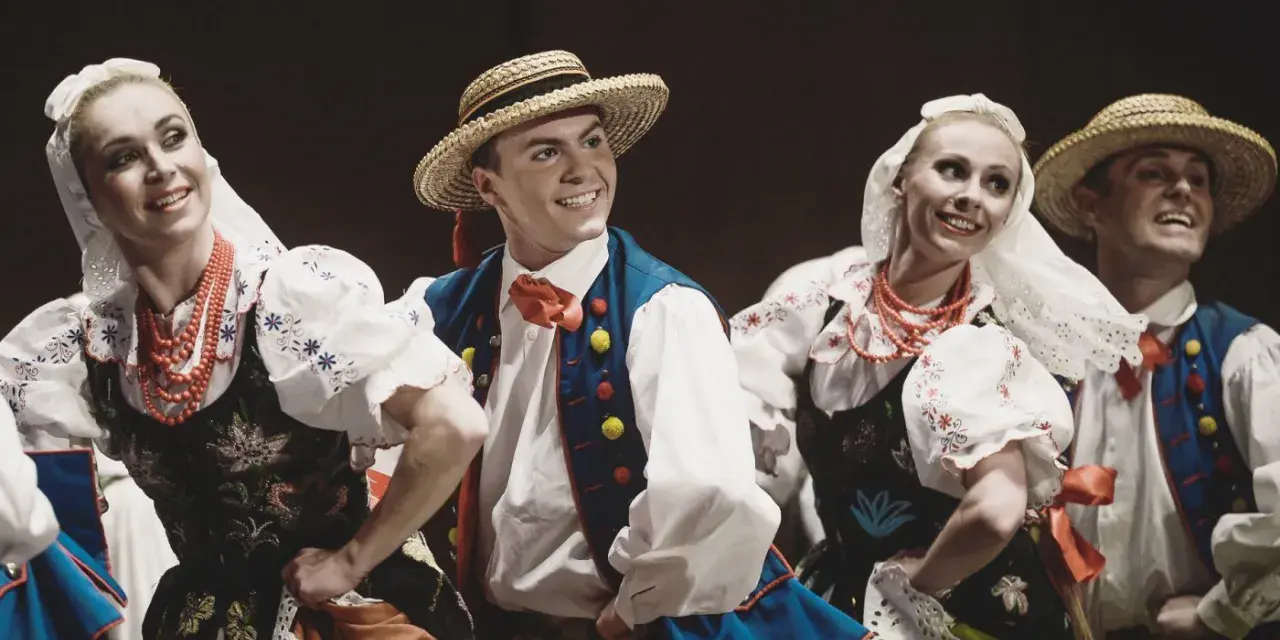 Tancerze w strojach ludowych, jakby Stanisław założył zespół Śląsk. Uśmiechnięci, w tradycyjnych strojach z haftami i koralami.