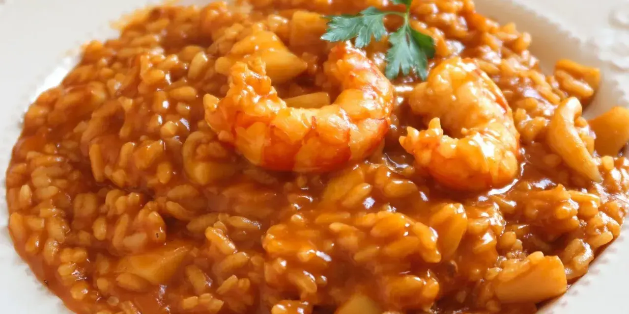 Delicioso arroz con mariscos, una de las mejores recetas de arroz. Servido en plato blanco con perejil fresco.